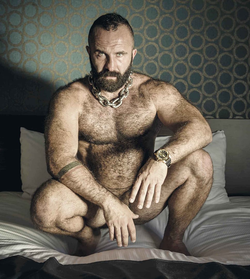 CERF: behaarter, baertiger Mann, sitzend auf dem Bett