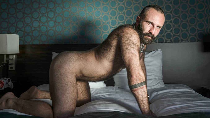 CERF behaarter, baertiger Mann auf dem Bett
